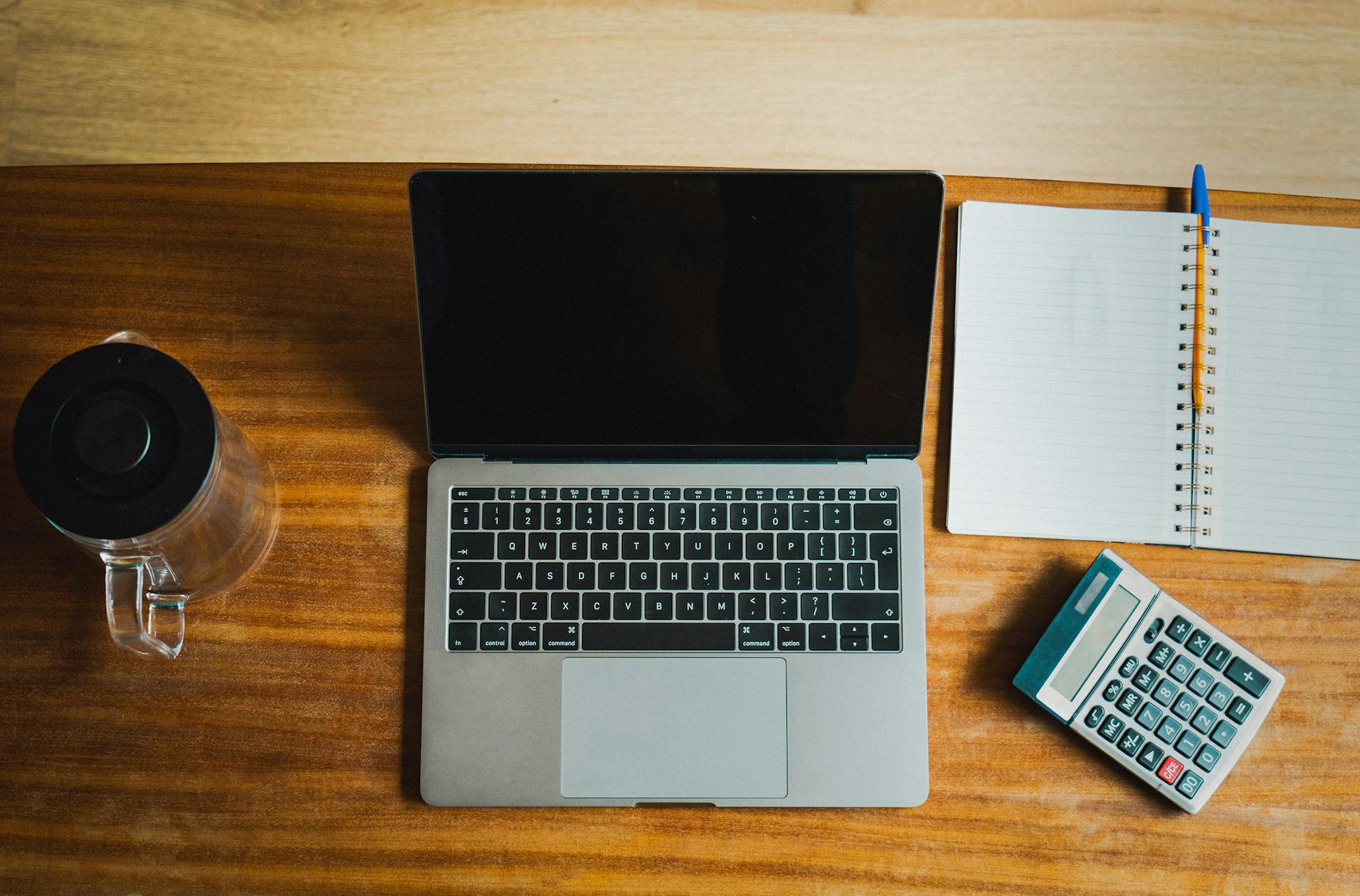 Accounting professional at desk with laptop, notebook and calculator — IFRS oil and gas training