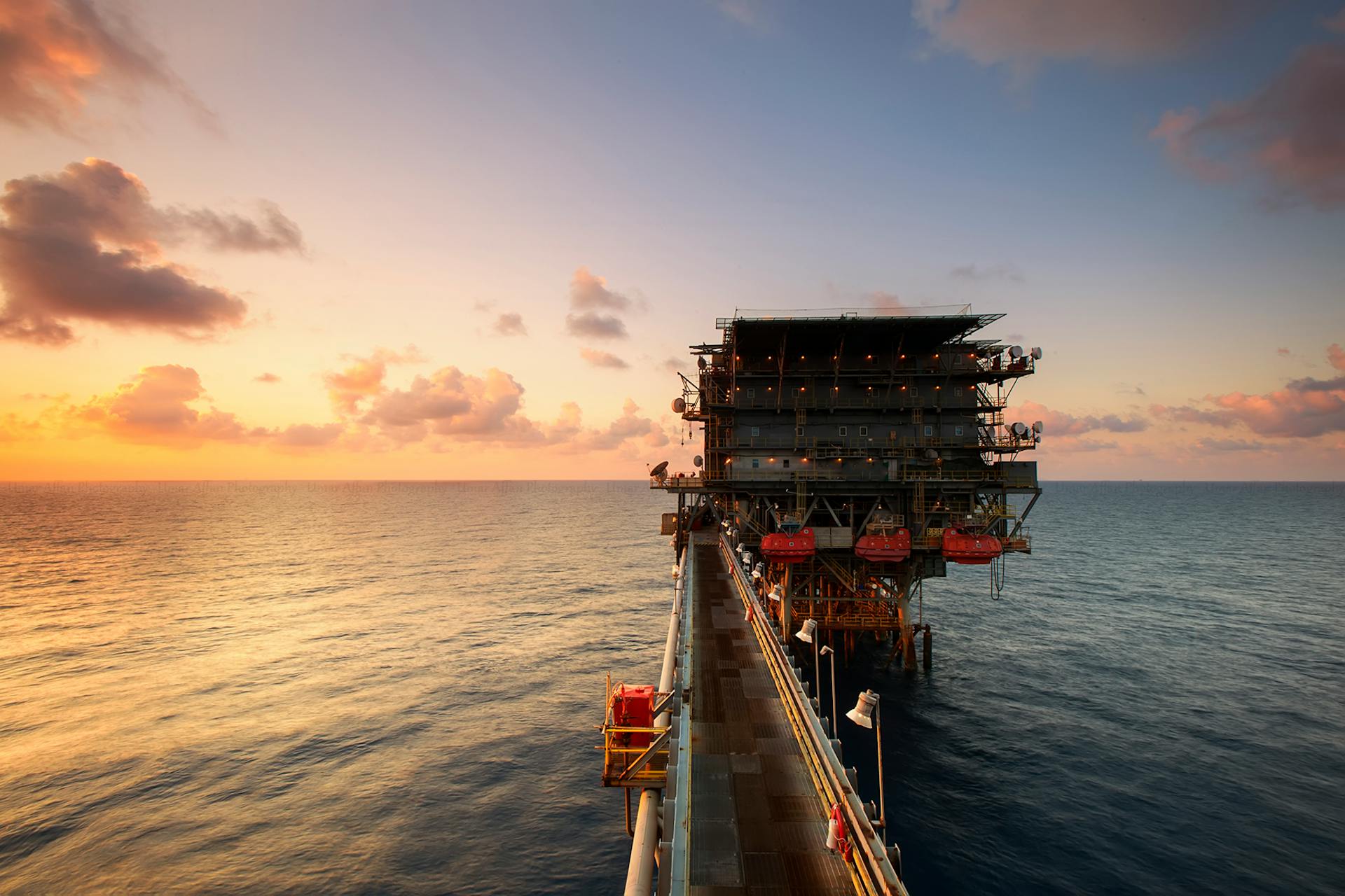 Drilling rig at dusk — World Fiscal Systems for Unconventional Oil and Gas